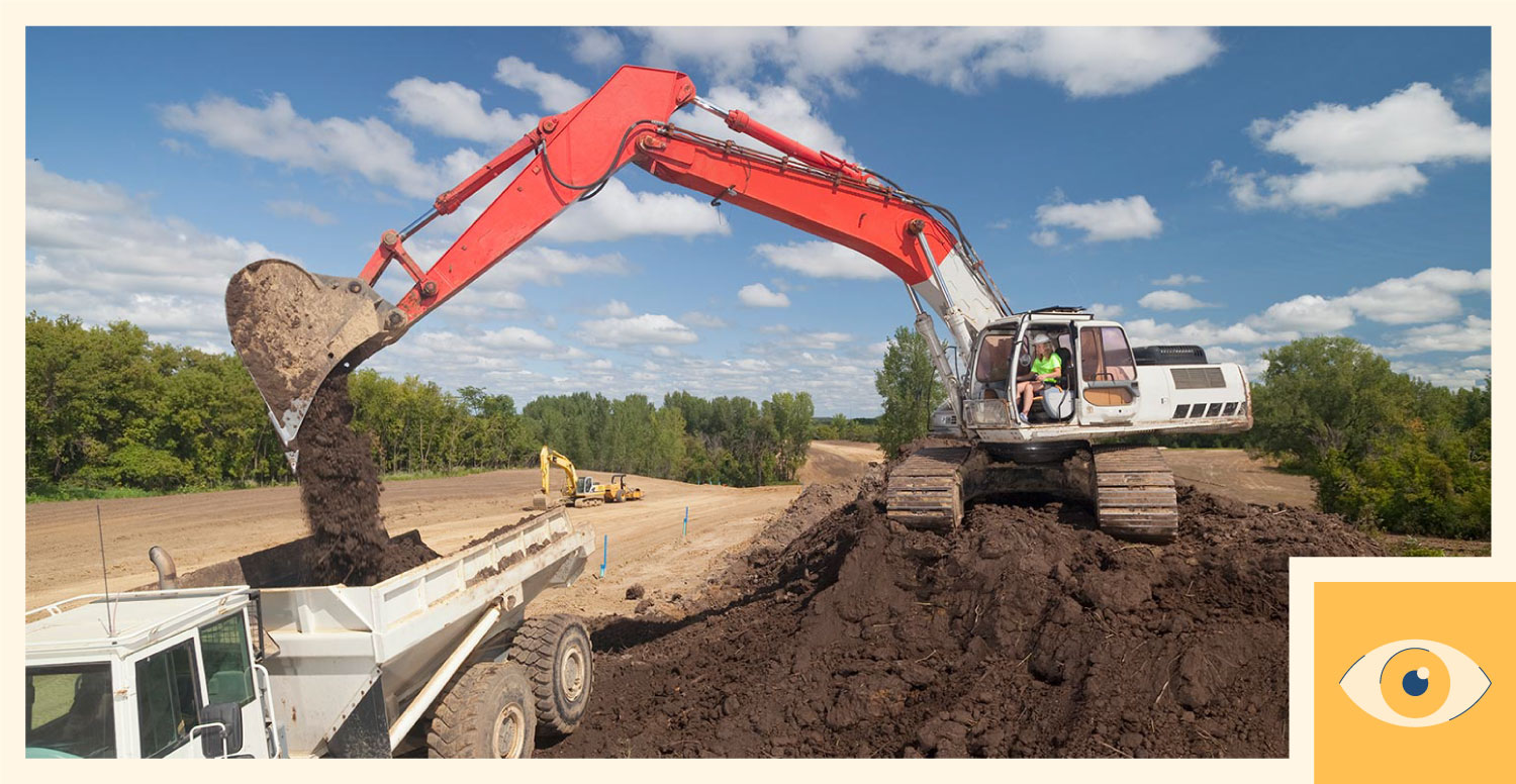 A construction worker operates an excavator.